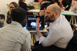 Trae Winter passionately talking with a young high school man about NASA satellites.